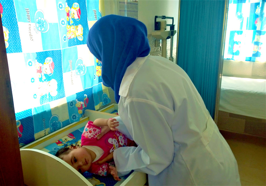Checking the baby’s weight at the Ahli Hospital ©AID/Julianne Stewart