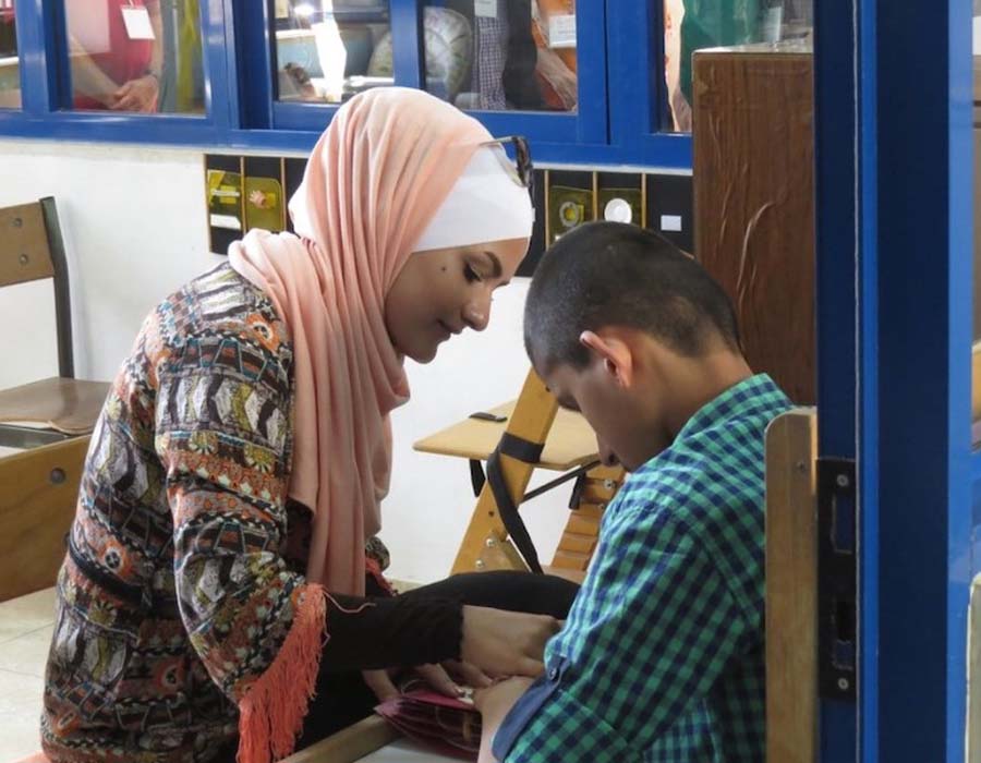 A teacher assists a student at the Holy Land Institute for the Deaf in Salt, Jordan. © American Friends of the Episcopal Diocese of Jerusalem.