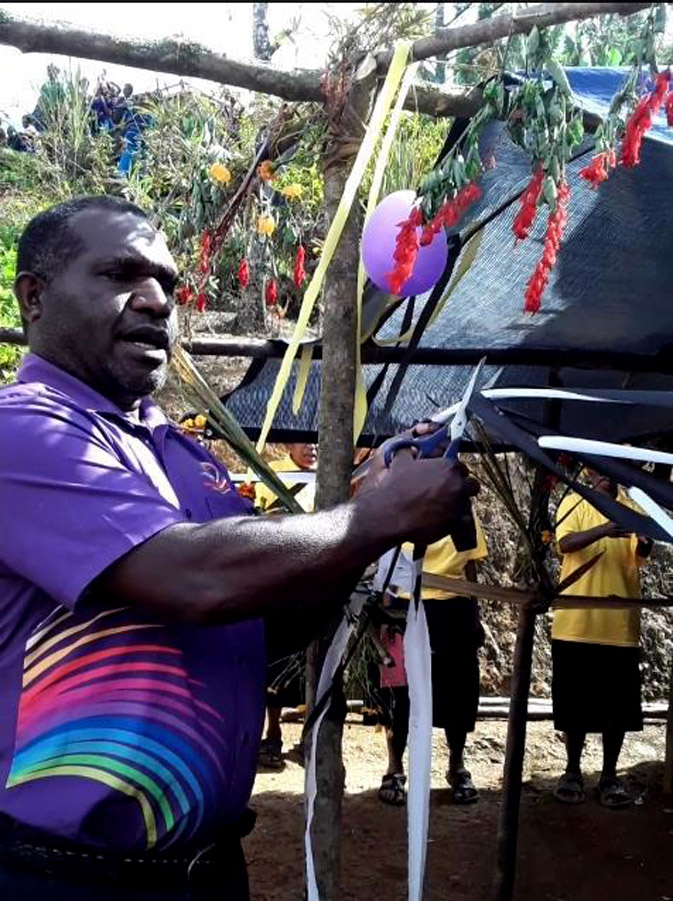 Anglicare PNG Mt Hagen Branch Manager, Ruben Fuafo, cut the ribbon to open a new Adult Literacy Classroom made from Kunai leaves. ©Morrison Wiam, Anglicare PNG