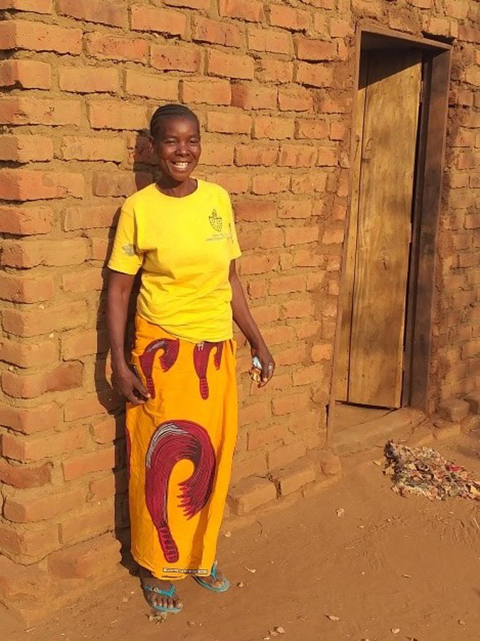 Esther shows off some of the bricks that she has been selling to community members which they are using to construct houses. ©YWCA, Zambia (ABM’s monitoring consultant in Zambia)