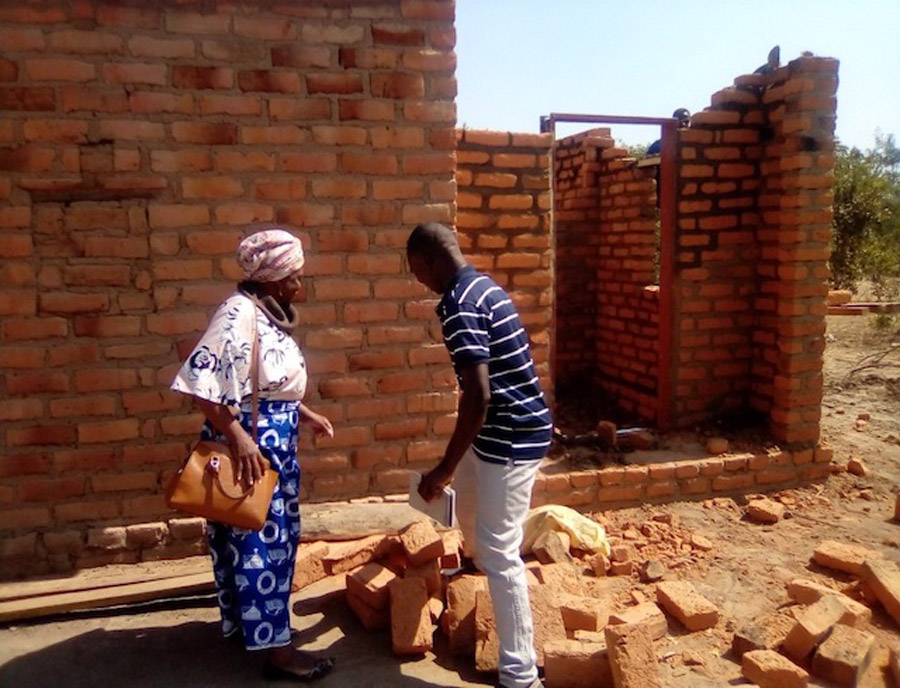 ZACOP’s Country Director, Mrs Felicia Sakala, talks with Selemani about the opportunities the project has given him, as he builds his house ©ZACOP