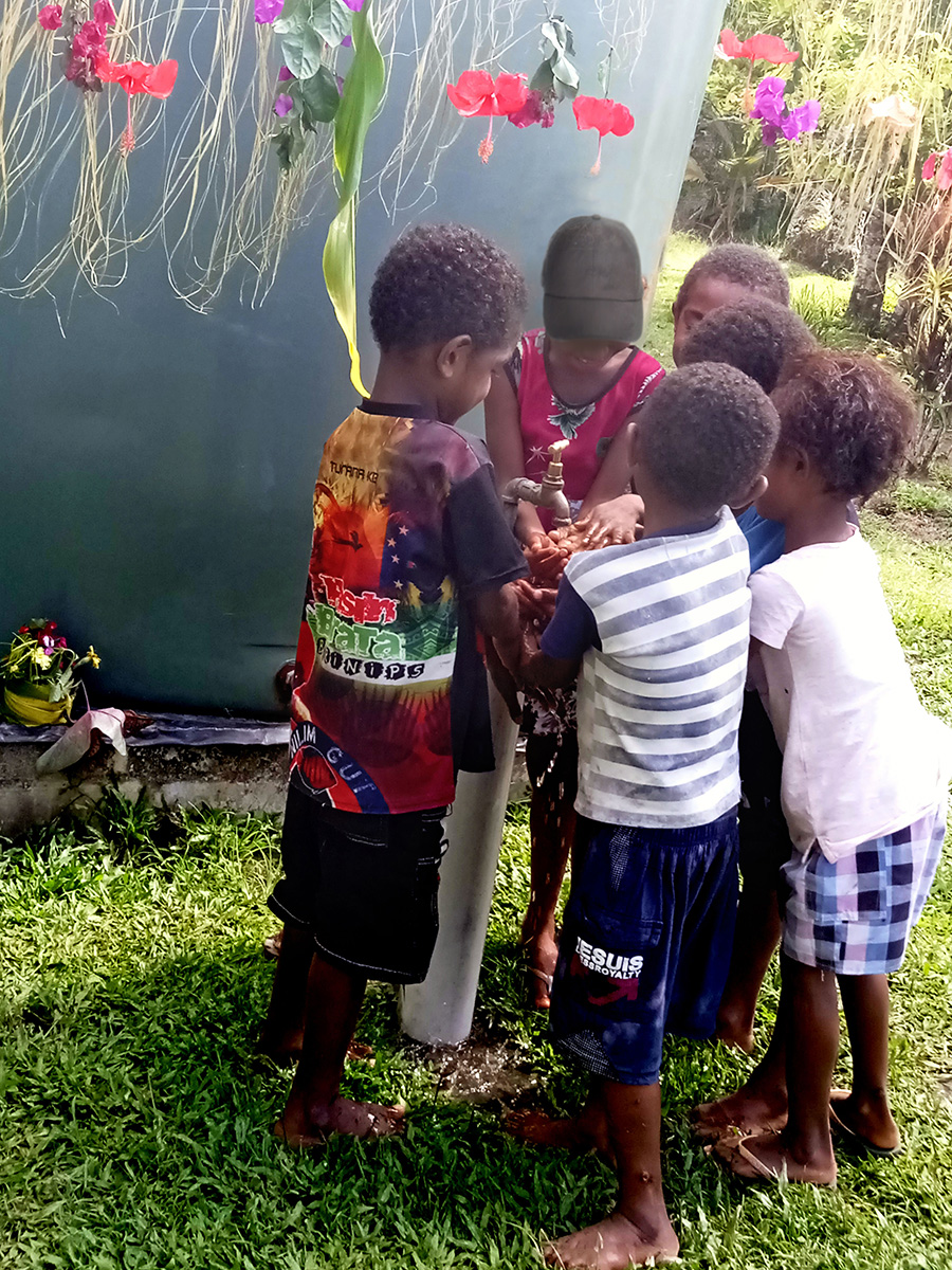 These children are delighted to wash their hands with clean rainwater from the tap.(C) Anglicare PNG.