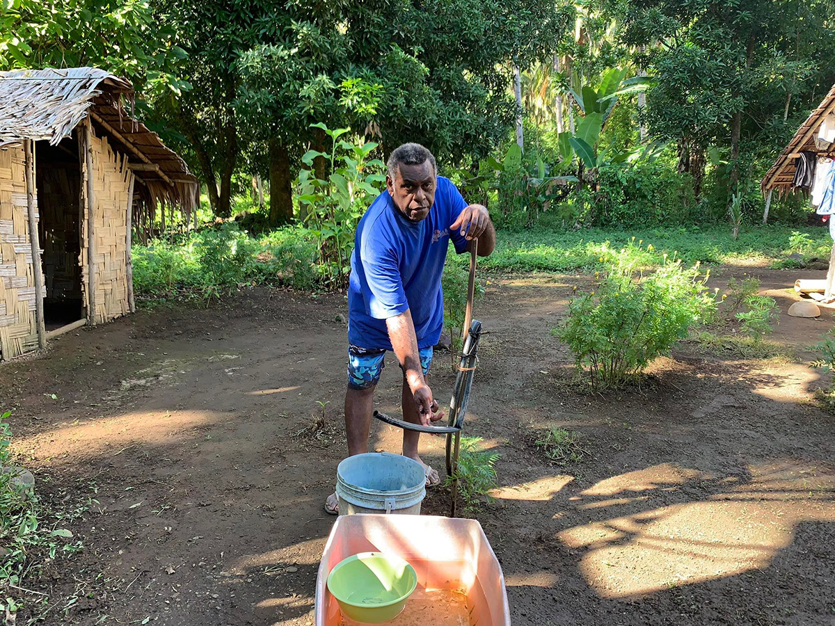 Chief Patrick Mark in Vanuatu demonstrates the new water point in his village. © Berry Johnathan and ACOM-V. Used with permission.