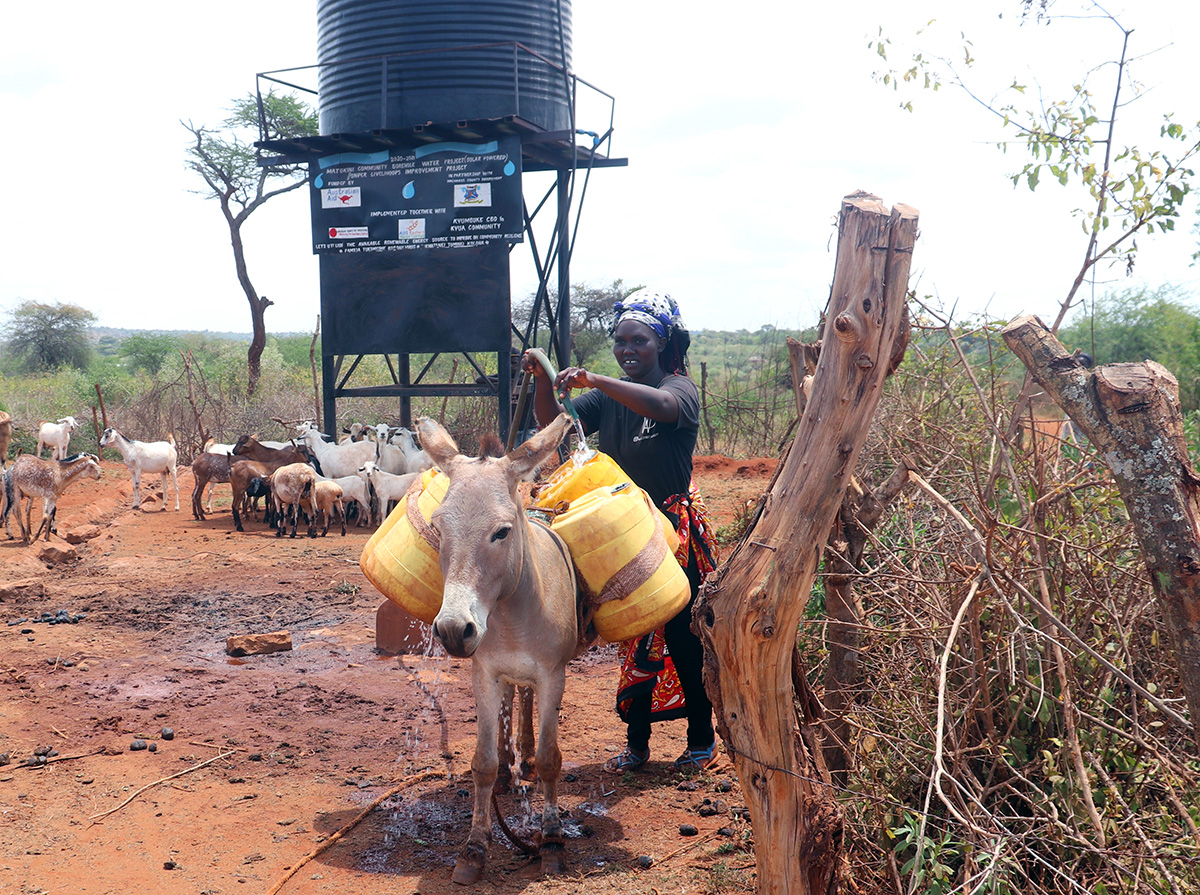 Sareh draws water from a tank for domestic use. © ADSE. Used with permission.