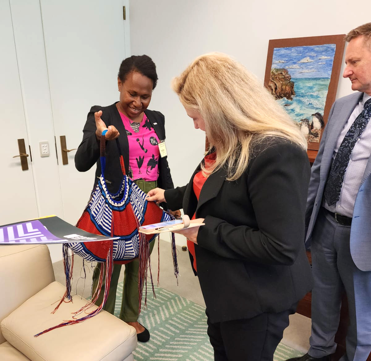 Cassendra showing shows Hon. Rebecca Sharkie her Bilum bag, made by her grandmother © Micah Australia