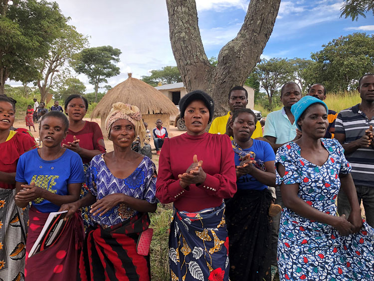 Women welcome visitors to village Koama Makasa March 2023. © Julianne Stewart, AID.