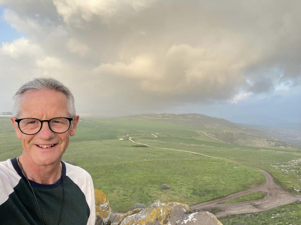 The Rev Canon Richard Sewell, Dean of St George's College in Jerusalem, with the Horns of Hattin, an extinct volcano in Israel, in the background. © Richard Sewell. Used with permission.