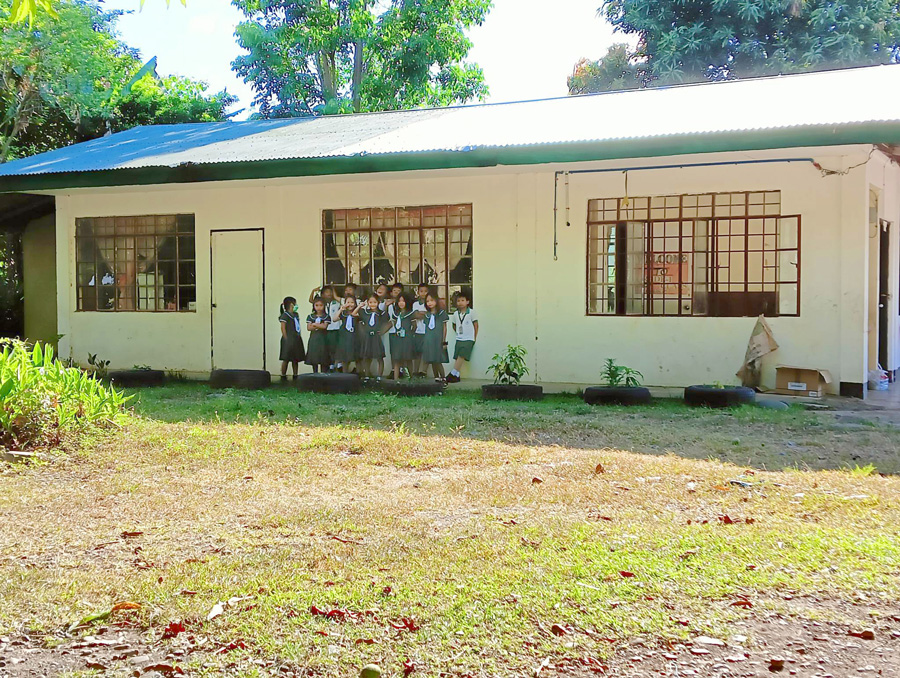 Children stand outside an existing classroom at St Mark’s Learning Centre ©ECP