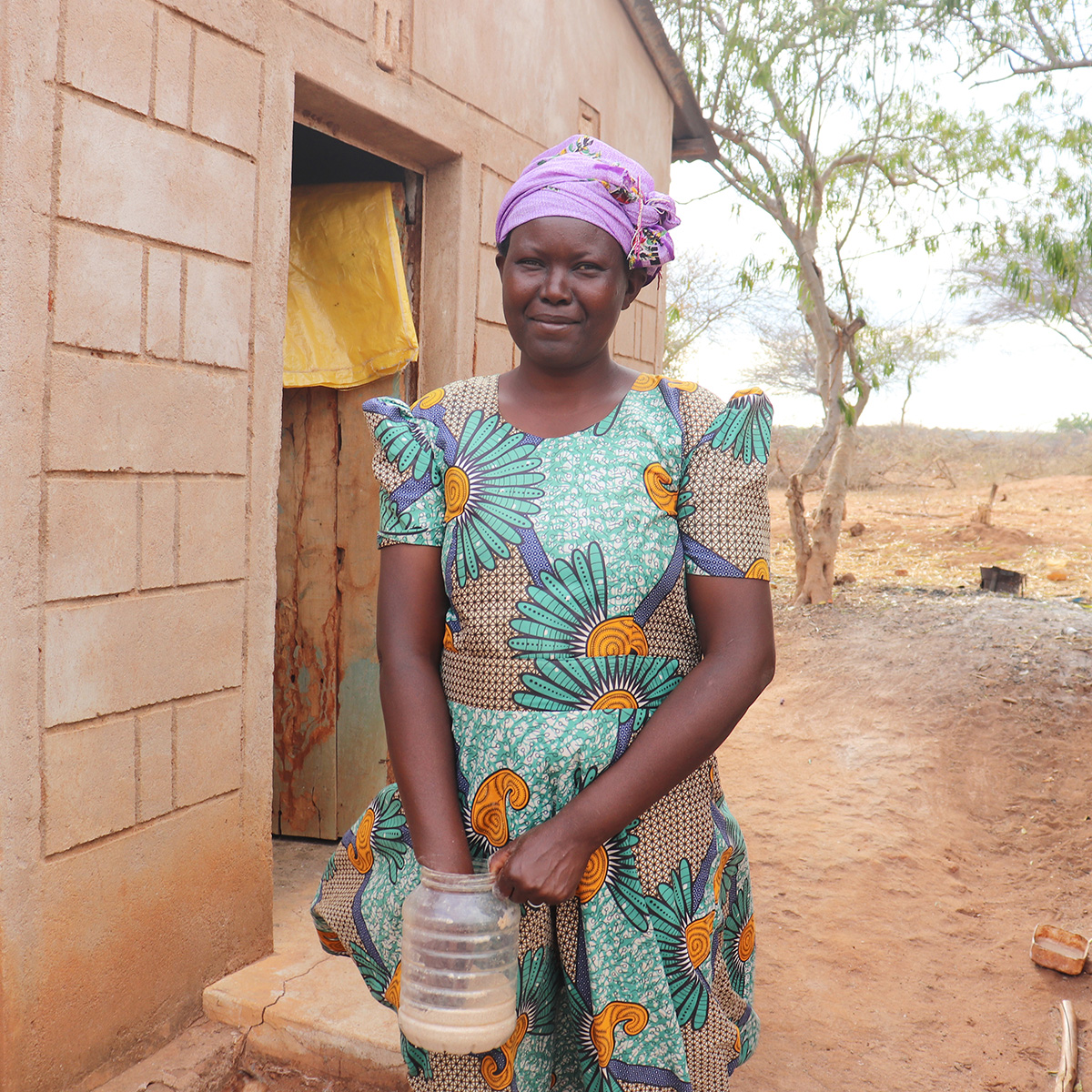 In Kenya, Catherine feeding her chickens. © ADSE. Used with permission.