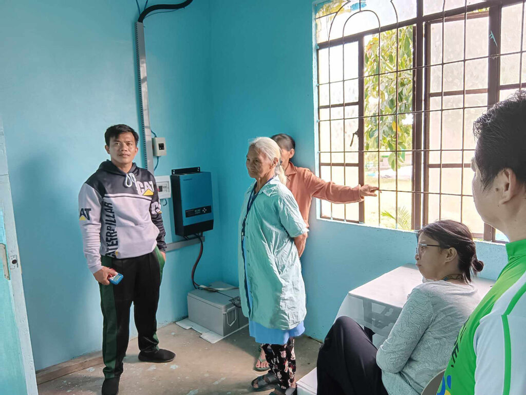 Honusan and Dominga with the solar power unit at St Vincent’s Episcopal Church in Magasuso, in Tabuk City.