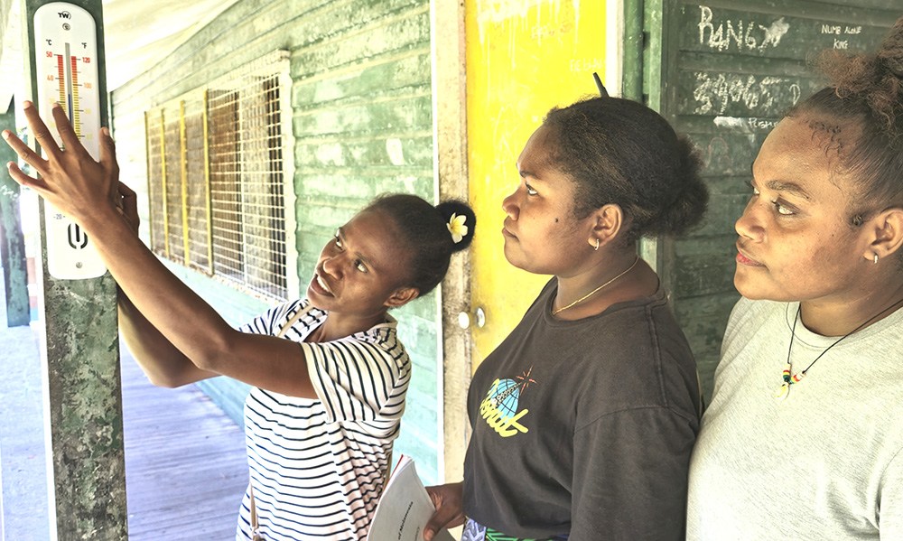 ACOM’s Freda Fataka (left) showing secondary students Margreth and Christalyn how to take temperature readings. Margreth (centre) says her favourite subject is science. “I have learned how to record scientific data,” she says. “Documenting this helps me understand about climate change. I feel sad that the shoreline is washing away.” © ABM/ Isabel Robinson.