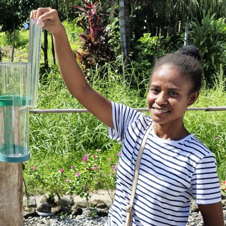ACOM's Freda Fataka checks the rain gauge at Panueli, Savo Island. “I have a passion for caring for nature,” she says. “I know that God created us, so we too need to be good stewards of Creation.” © ABM/ Isabel Robinson.