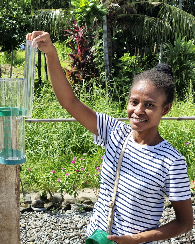 ACOM's Freda Fataka checks the rain gauge at Panueli, Savo Island. “I have a passion for caring for nature,” she says. “I know that God created us, so we too need to be good stewards of Creation.” © ABM/ Isabel Robinson.