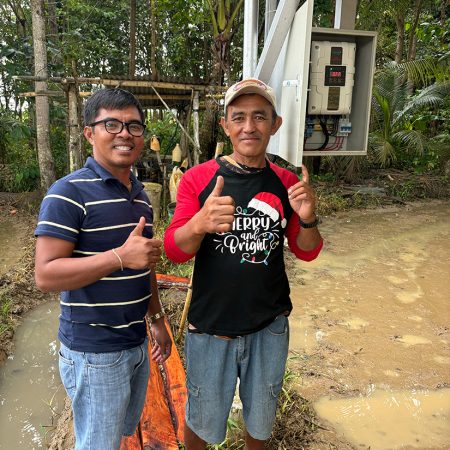 Rice farmer Joey (r) has received training from certified electrician Edward in how to maintain the recently installed solar panels and pump that service 4 ride.
