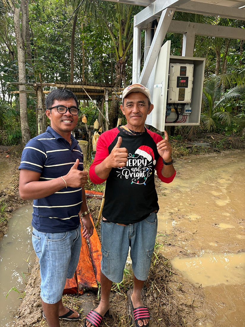 Rice farmer Joey (r) has received training from certified electrician Edward in how to maintain the recently installed solar panels and pump that service 4 ride.