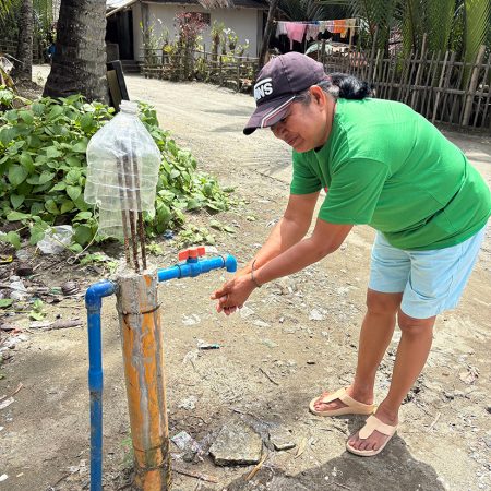 Rufina is able to access running water near her home thanks to newly installed rain water tanks in her community. © ABM/Meagan Schwarz.