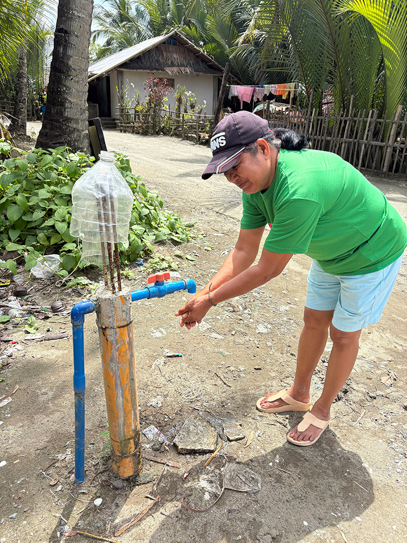 Rufina is able to access running water near her home thanks to newly installed rain water tanks in her community. © ABM/Meagan Schwarz.