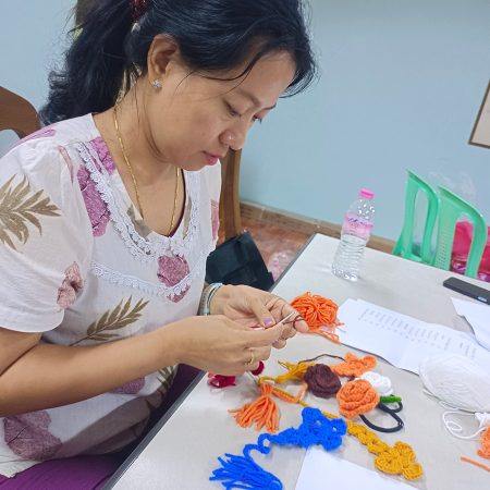 Su Su Zin Maung makes crosses from yarn which she then sells for income. © CPM. Used with permission.