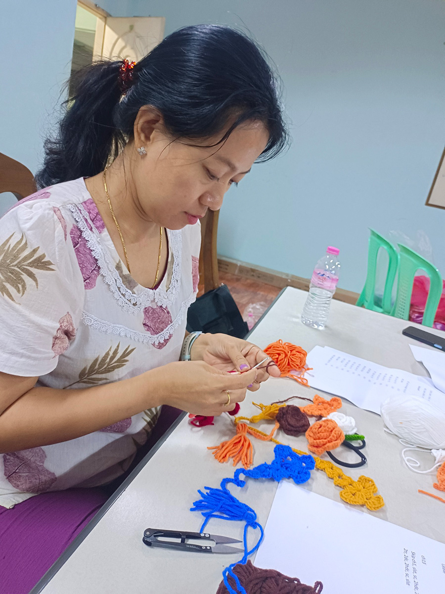 Su Su Zin Maung makes crosses from yarn which she then sells for income. © CPM. Used with permission.