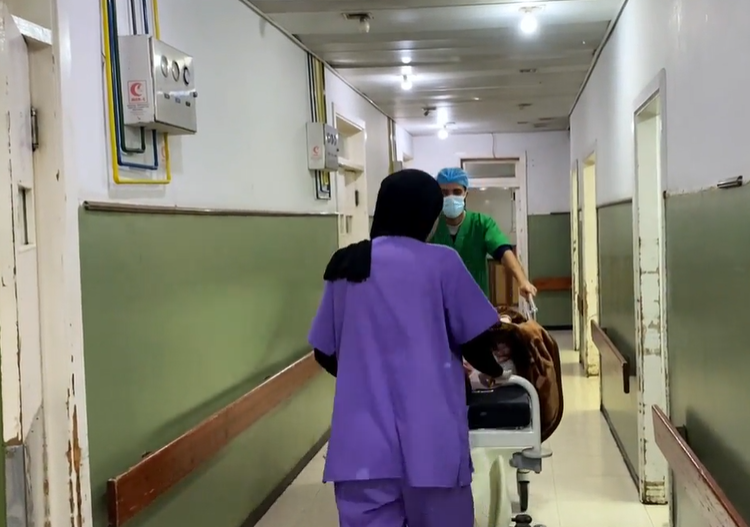 Staff at Al Ahli Arab Hospital wheel a patient down a corridor © Diocese of Jerusalem