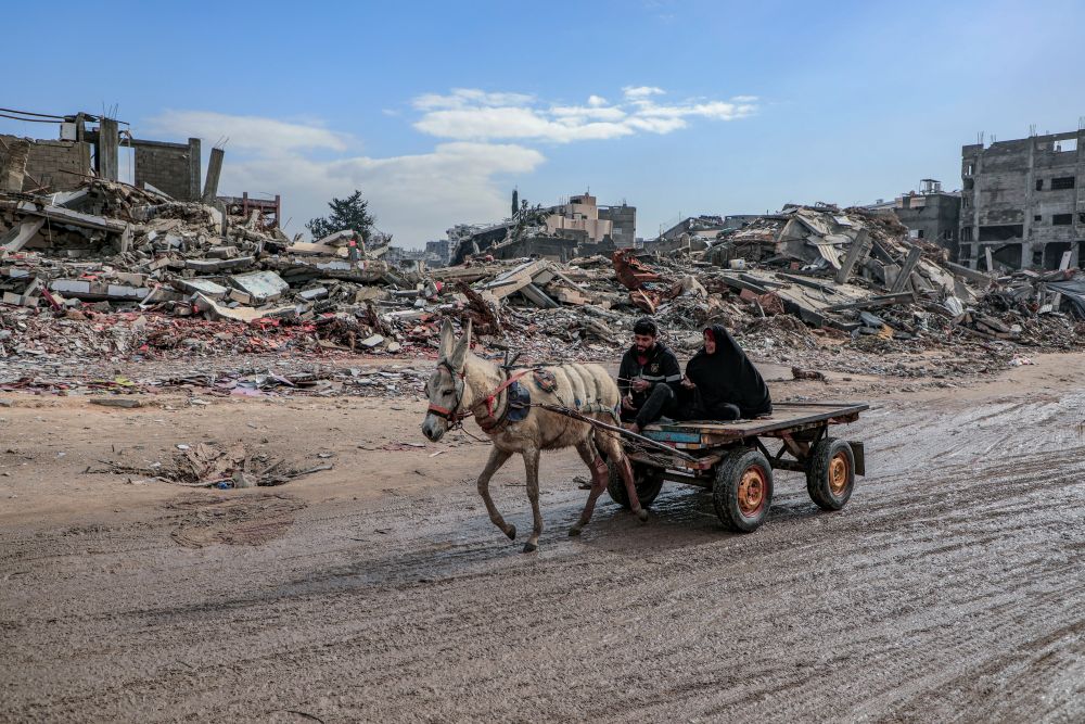 Gaza-Palestine. Amid the massive destruction, a young man and his mother drive a cart through the streets