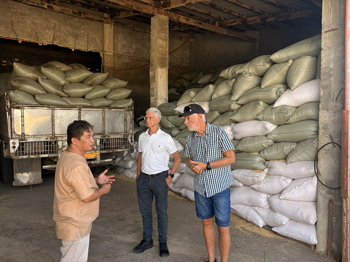 Rod and Brad Rulfs with Padi Ralph, priest and CEO of the Holy Spirit Mission Cooperative, inspecting bagged rice ready to be milled. © ABM