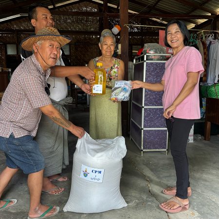 CPM staff and volunteers bring emergency relief supplies to a community member affected by flooding © CPM. Used with permission.