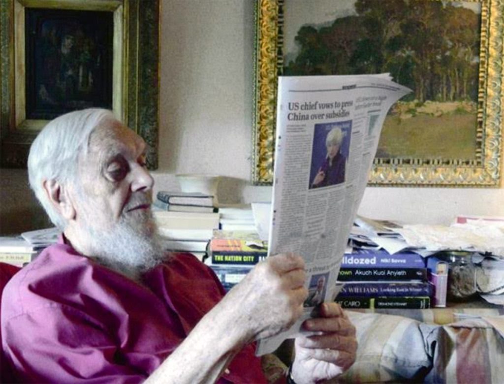 Fr Charles reading the latest news at home.