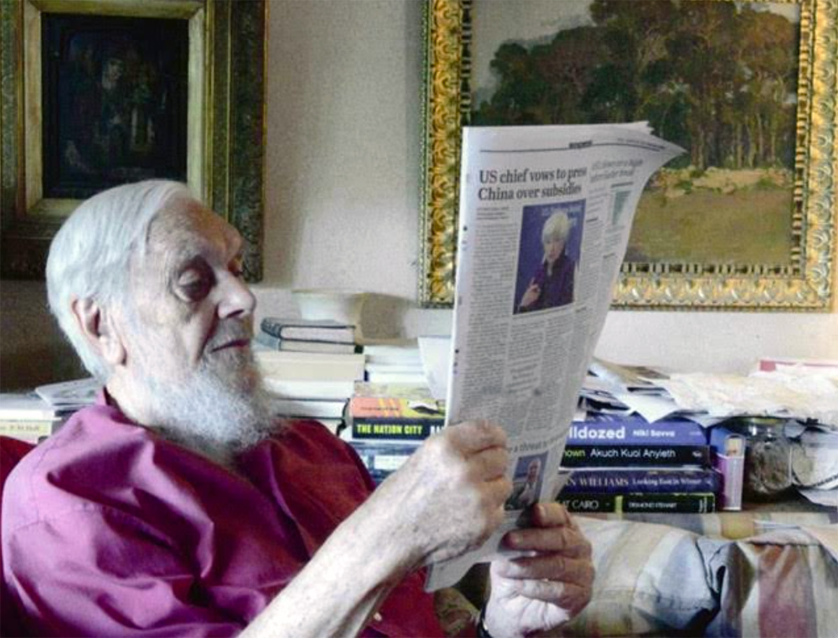 Fr Charles reading the latest news at home.