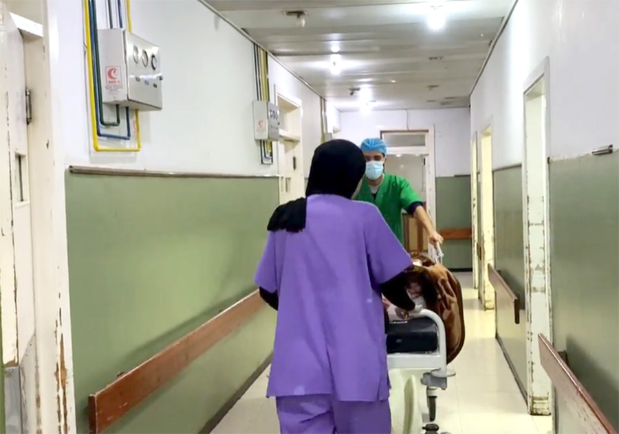 Staff at Al Ahli Arab Hospital wheel a patient down a corridor © Diocese of Jerusalem